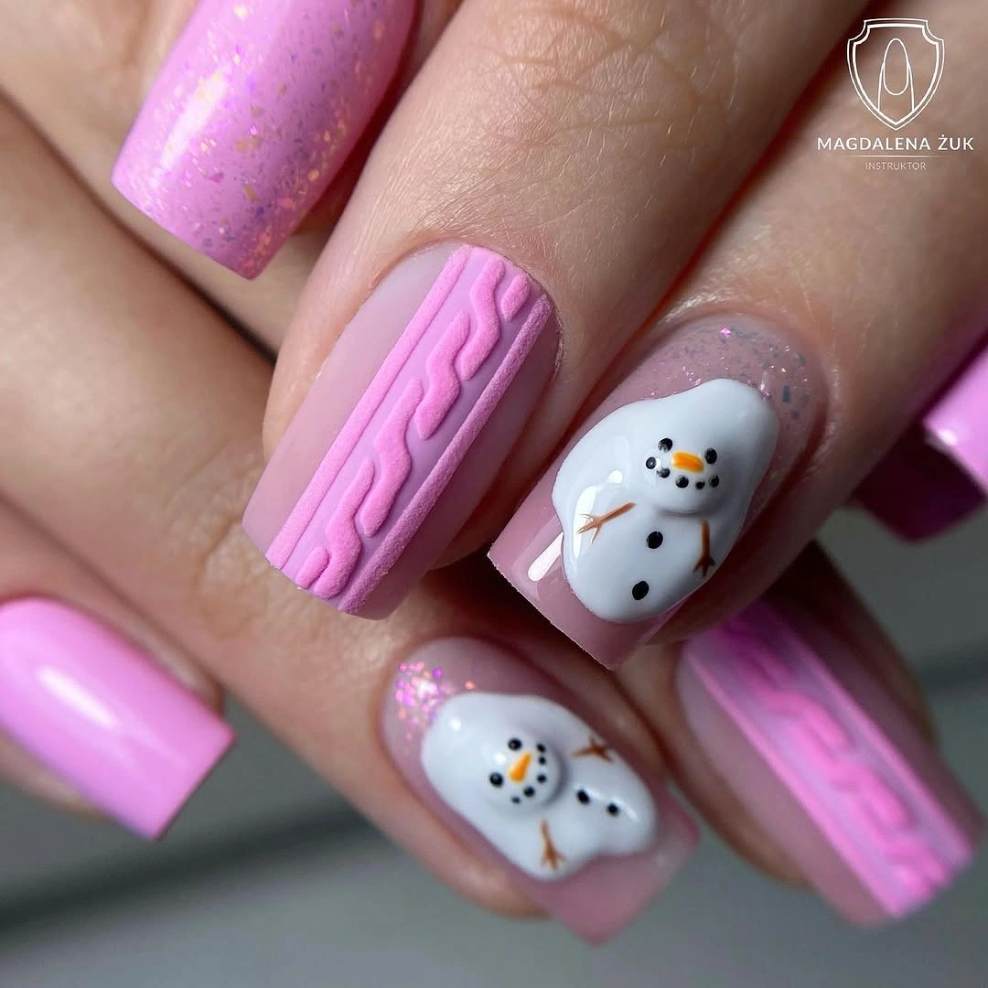 Long square pink nails with raised-looking sweater patterns and white snowman decorations.