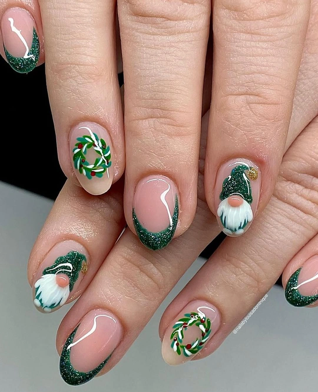 Short pink nails with green glitter tips, wreaths, and white holiday figures.