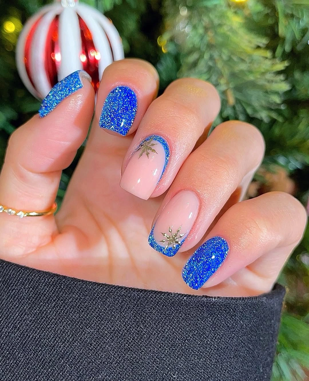 Short square nails with blue glitter, blue French tips, and gold details.
